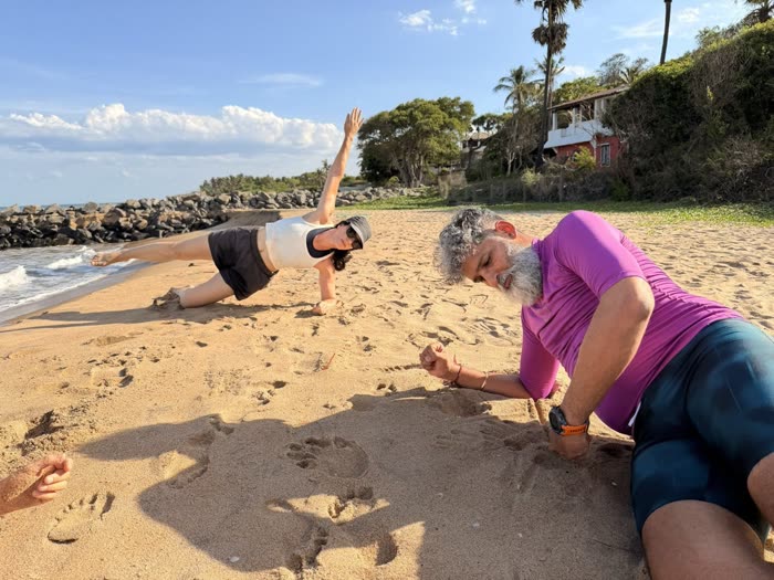 Rotem guiding a client's side-plank form down at sand level